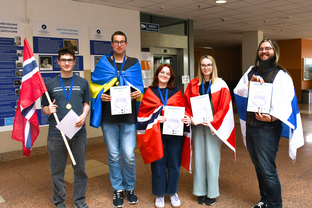 Pięć osób stoi w holu Collegium Humanisticum, trzymając dyplomy i flagi różnych państw skandynawskich.